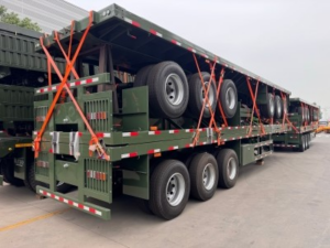 A batch of customized 3-axle flatbed semi-trailers is ready to roll off the production line.